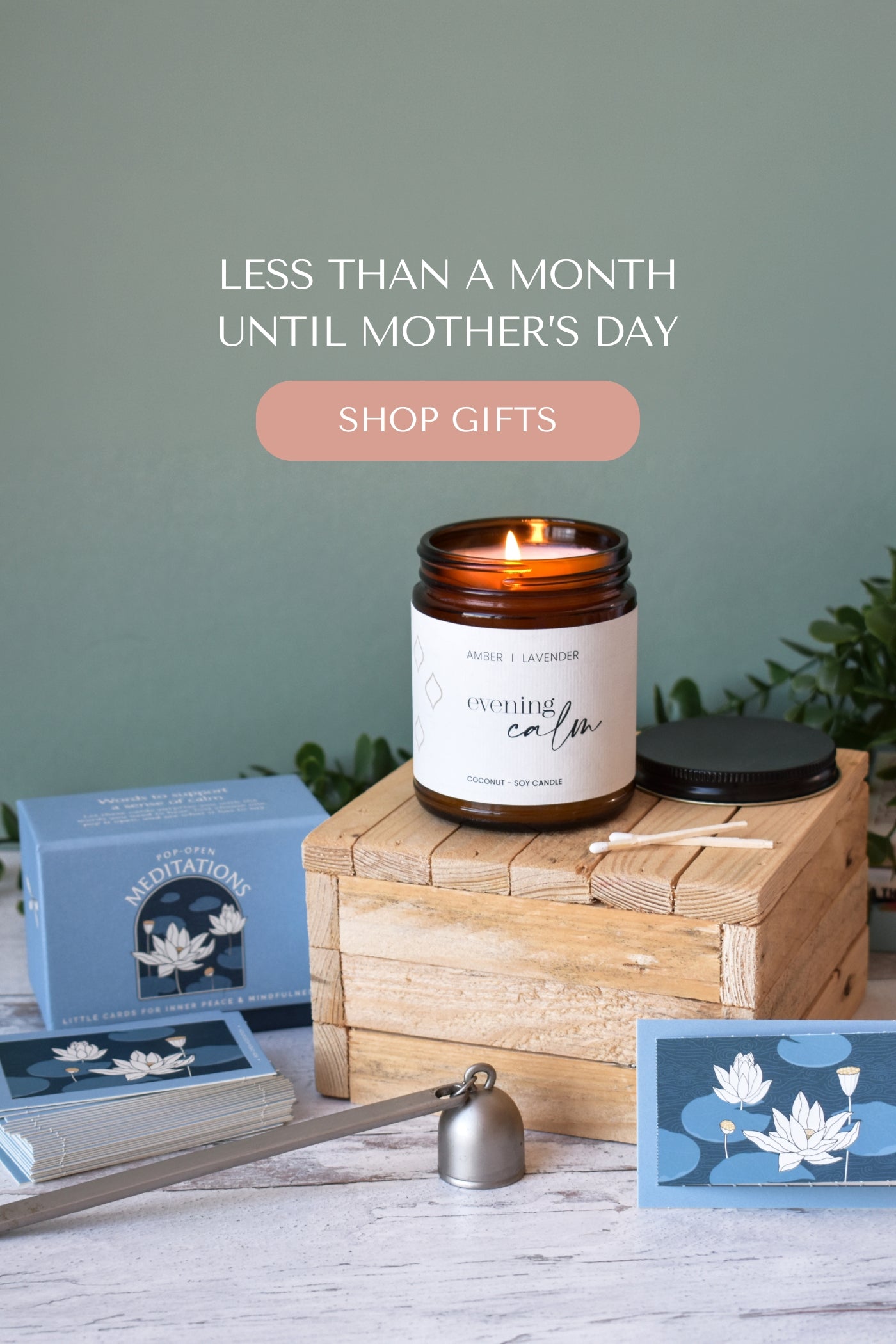 Candle with 'evening calm' label on a wooden box, surrounded by gift items with text about Mother's Day.