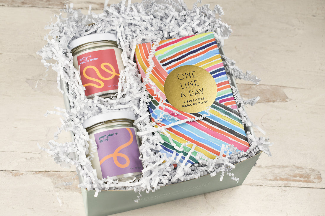 A gift box set containing two glass jars with colorful labels and a striped book titled &