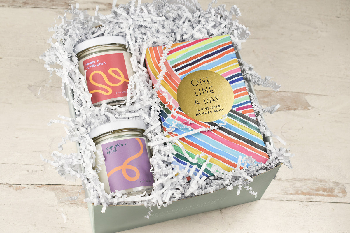 A gift box set containing two glass jars with colorful labels and a striped book titled &