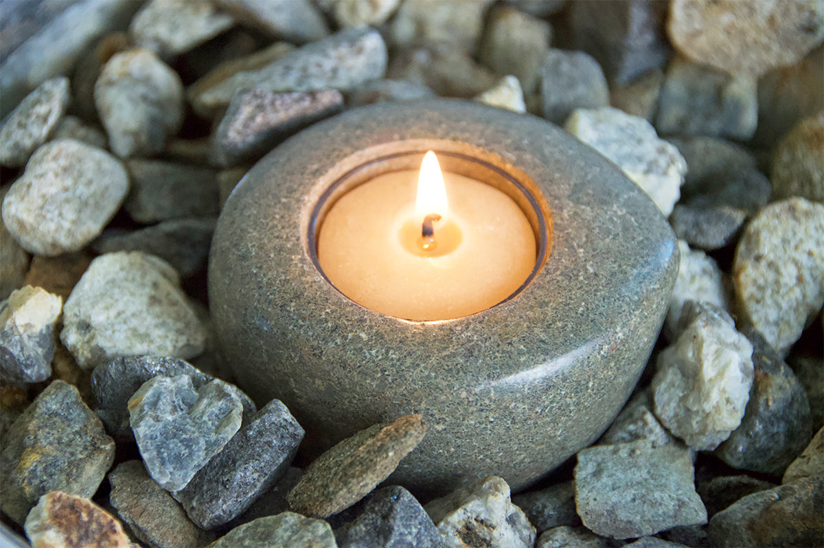 Hand-carved riverstone tea light made in Haiti by artisans with 100% pure beeswax tea lights.